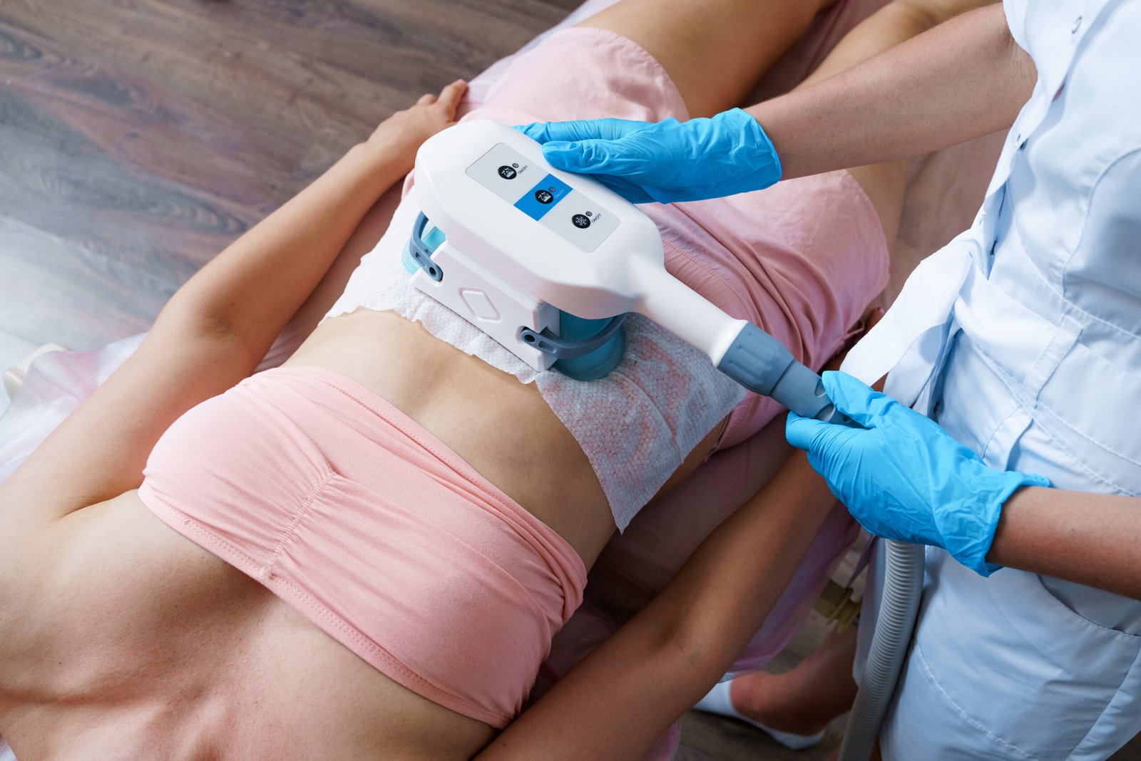 Woman during abdominal massage or body shaping procedure. Body care. Ultrasonic cavitation body contour. Radiofrequency therapy. Active thermolysis. Rise. Body massage with bipolar radiofrequency